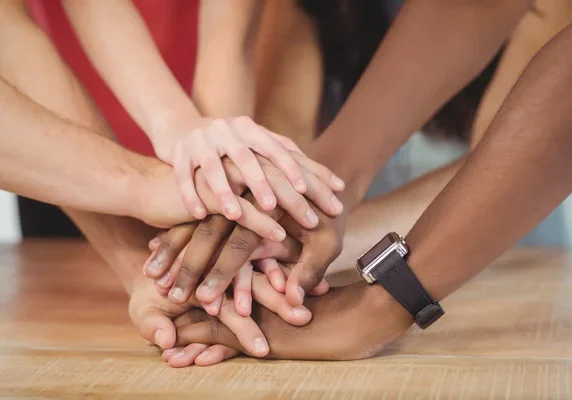 photo of people putting their hands together